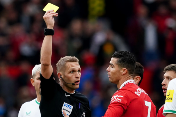 Football referee showing a yellow card during a match